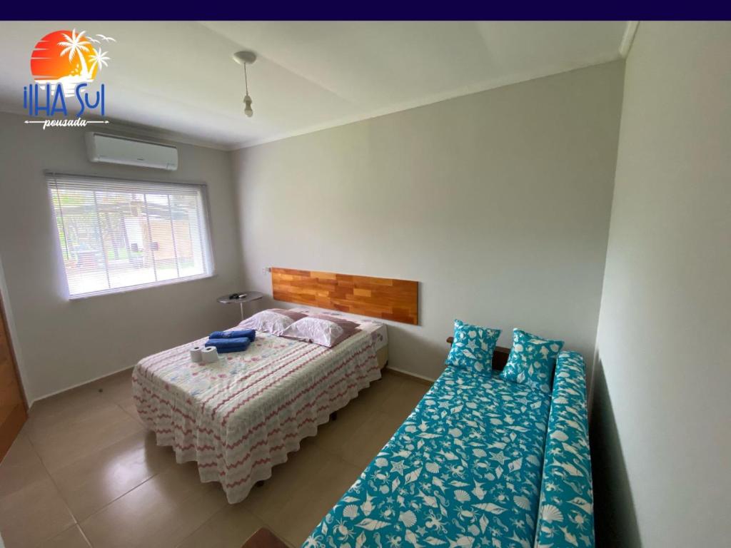 a bedroom with a bed and a couch and a window at Pousada Ilha Sul in Cananéia