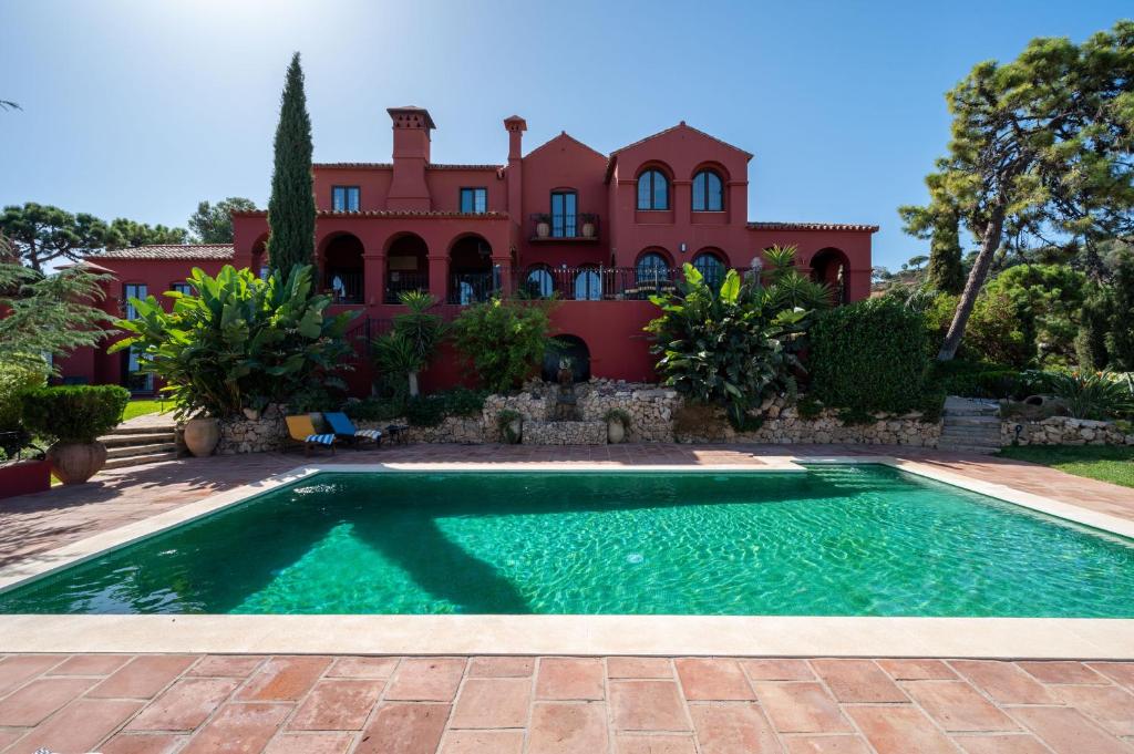 uma casa com piscina em frente a uma casa em Villa Melenchin em Málaga