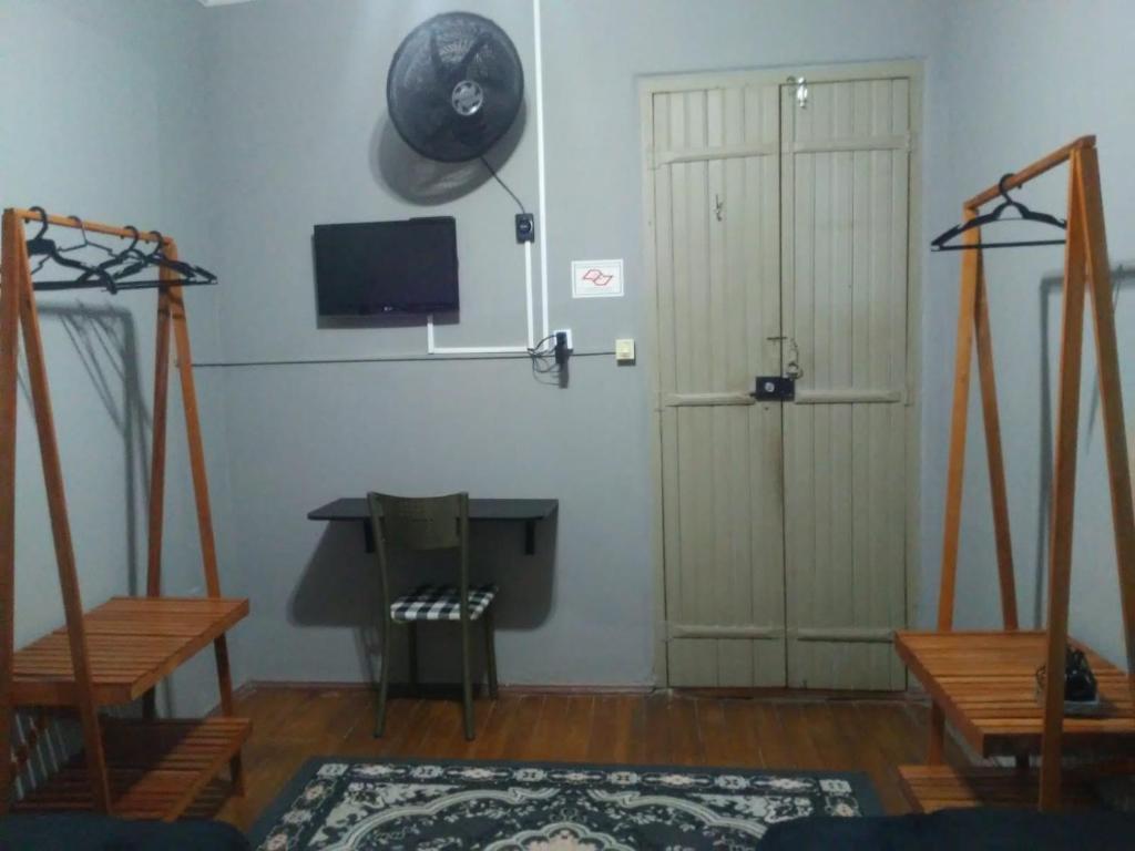 uma sala de estar com uma mesa e uma televisão e uma porta em Pousada uberaba em Uberaba