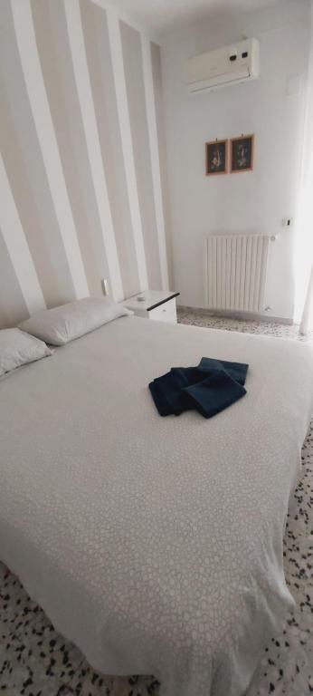 un letto bianco con un tovagliolo blu sopra di Mont Saint Michel a Bari