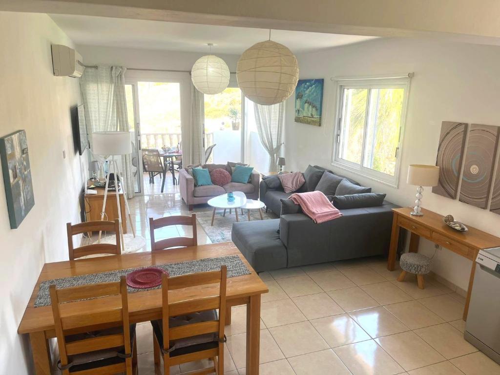 a living room with a couch and a table at Peyia Resort Apartment in Peyia