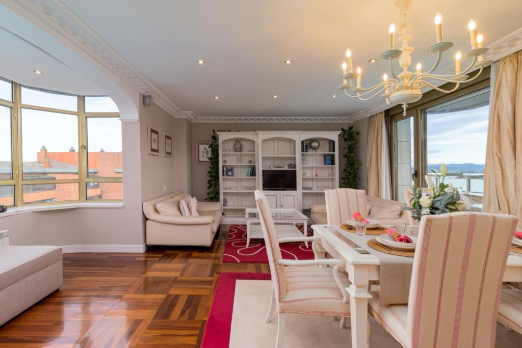 a living room with a table and chairs and a dining room at Apartamento Luminoso Cerca Playa Sardinero Con Parking Privado in Santander