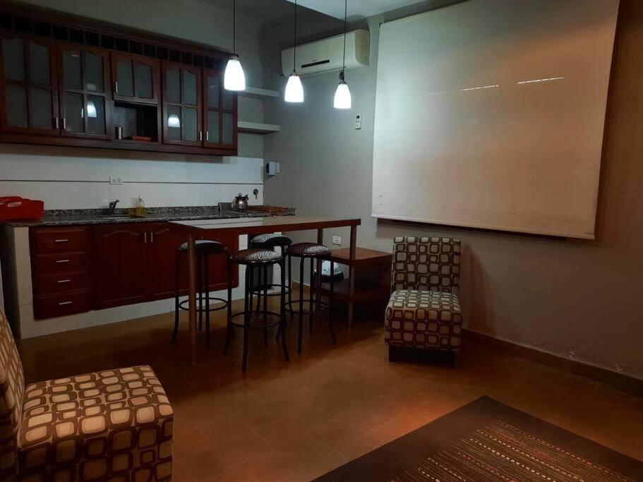 een keuken met een bar en krukken in een kamer bij Shallor Cryss Polonia in San Miguel de Tucumán