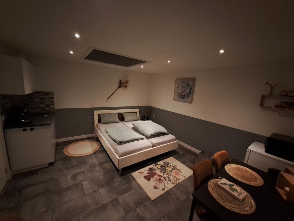 1 dormitorio con cama, mesa y cocina en studio ' aan de Nieuwstraat ' Sint Annaland, en Sint Annaland