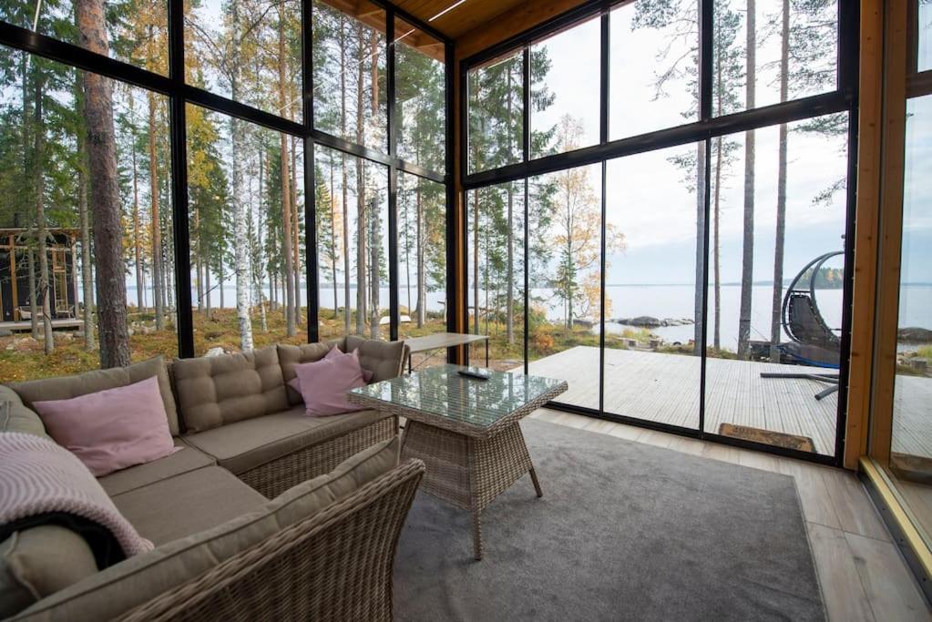 uma sala de estar com um sofá e uma mesa de vidro em Rantarovio em Alvajärvi