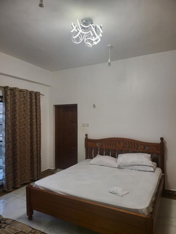 a bedroom with a bed with a light above it at Meshaal heights in Mombasa