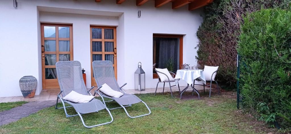 特倫托的住宿－Villa Natura appartamento Open Space con giardino，院子里的一组椅子和一张桌子