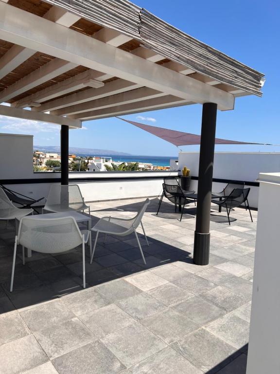 d'une terrasse sur le toit avec une table et des chaises. dans l'établissement Florí, à Reitani