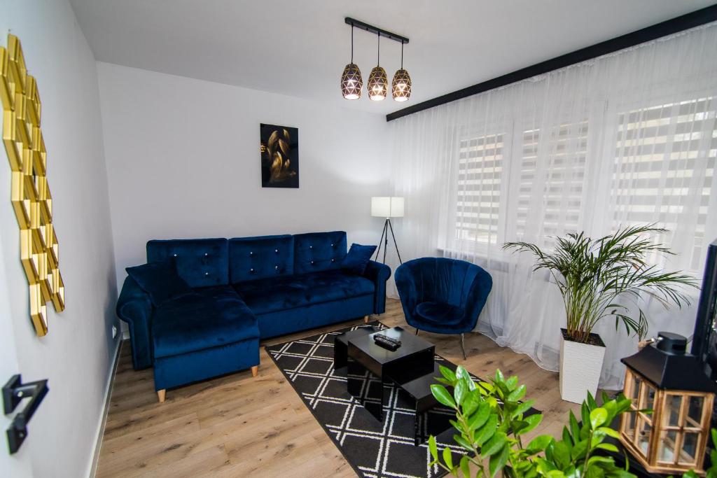 a living room with a blue couch and a table at Apartament w Centrum in Iława