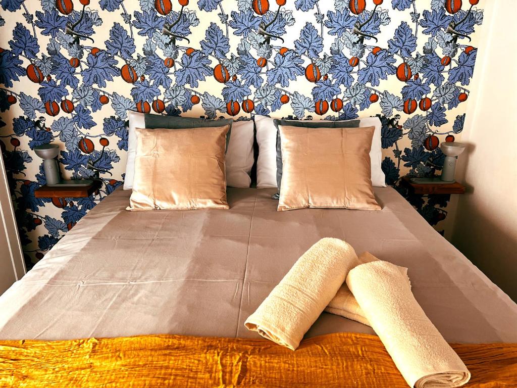 a bed with two pillows and a blue and orange wall at San Ranieri Tiny Tower in Pisa