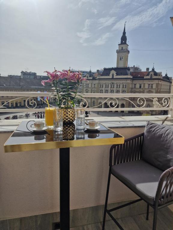 a table with a vase of flowers on a balcony at Queen Palace in Novi Sad