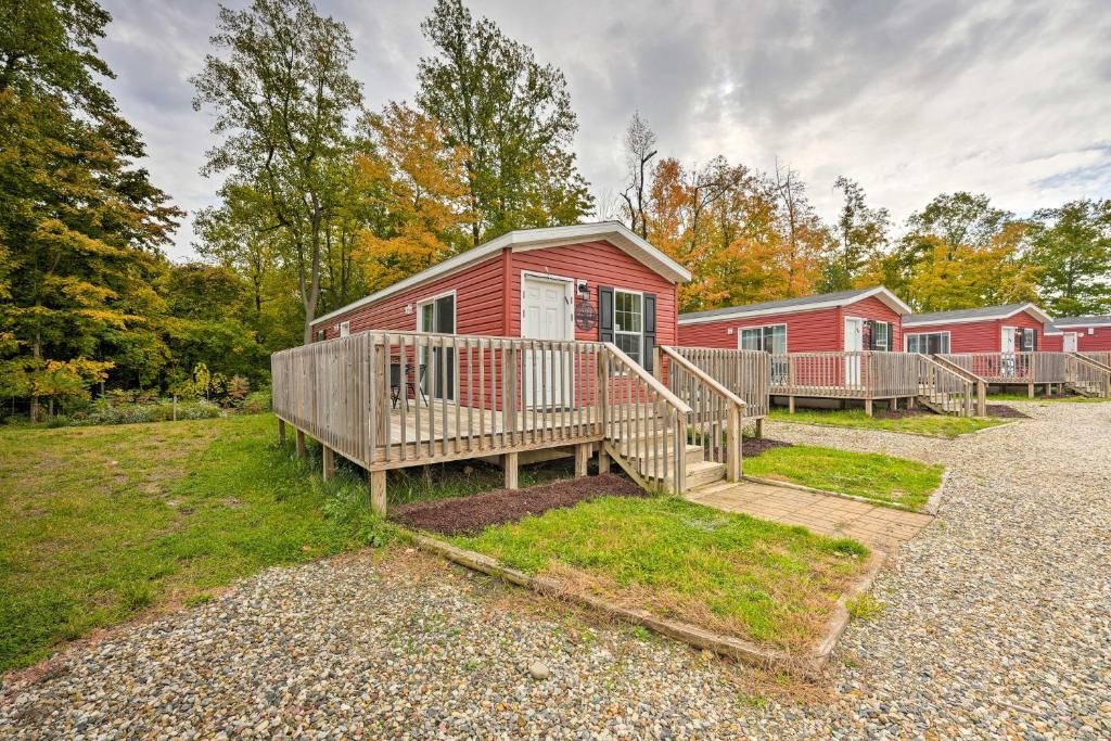 ein rotes Haus mit einer Veranda und einer Terrasse in der Unterkunft Pet-Friendly Cassopolis Escape with Lake Access in Cassopolis