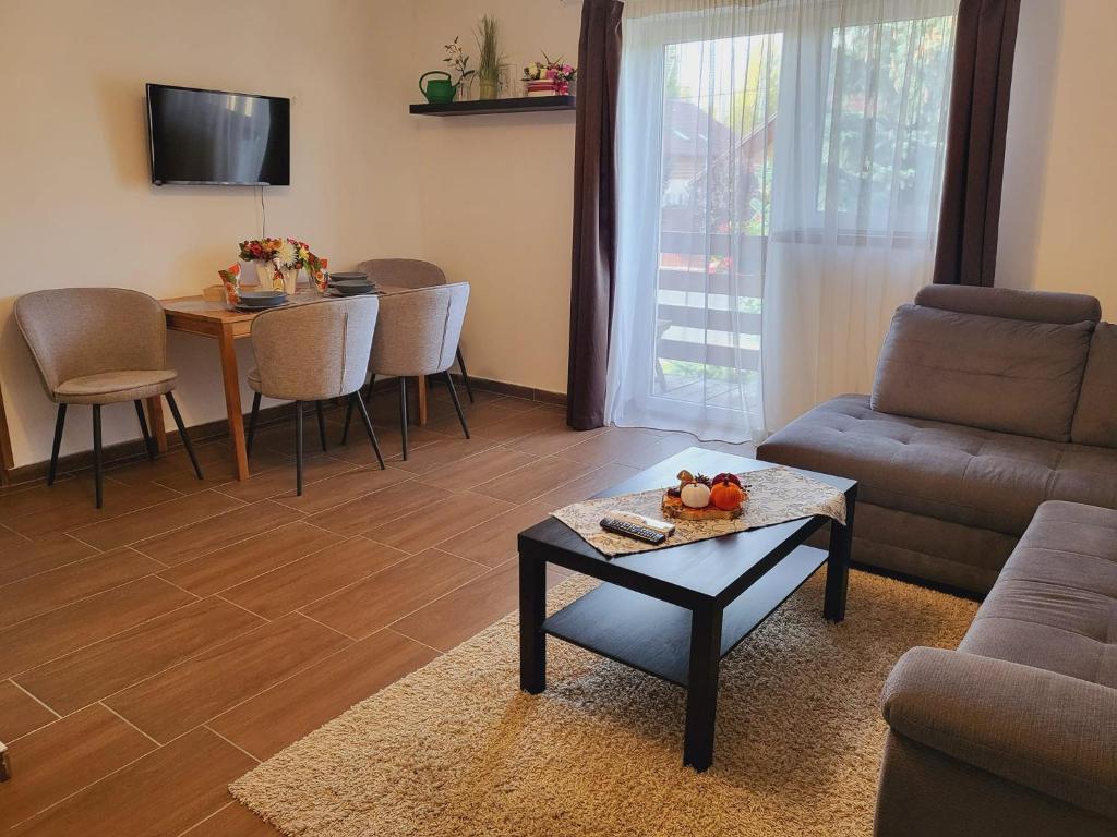 a living room with a couch and a table at Olivér Apartmanház in Balatonlelle