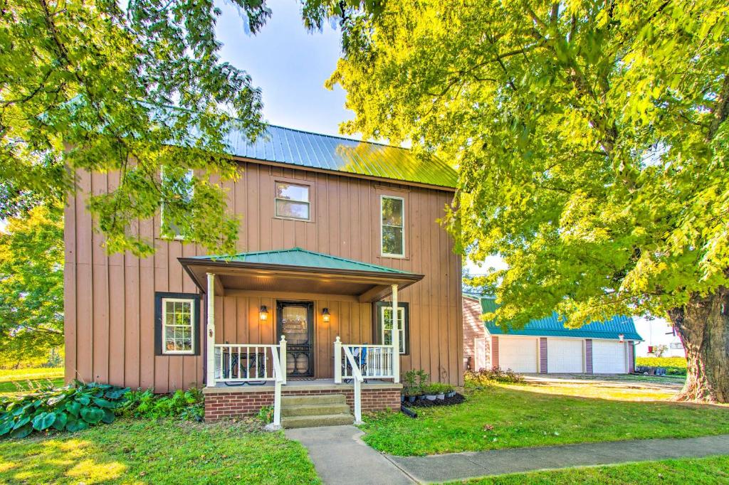 a home with a gambrel roof and a garage at Beautifully Restored Farmhouse in Marshall! in Marshall