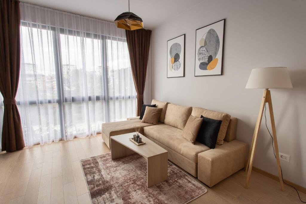 a living room with a couch and a table at LINA - PG, Moraca River Apartment in Podgorica