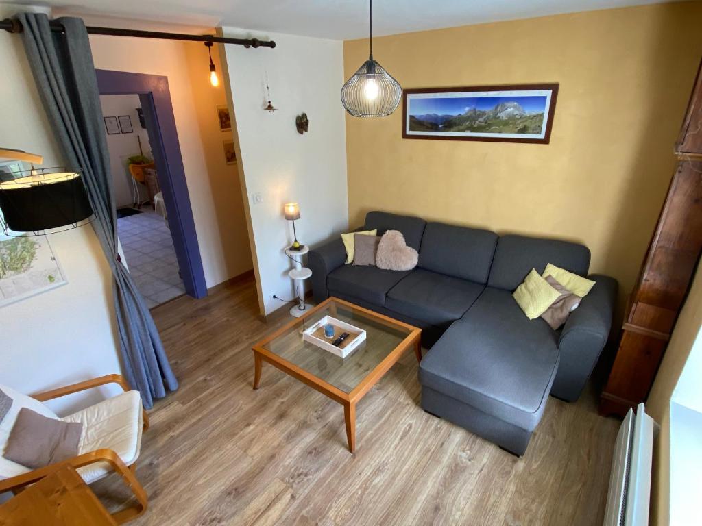 sala de estar con sofá y mesa en La petite marmite du lac de Vouglans, en Pont-de-Poitte