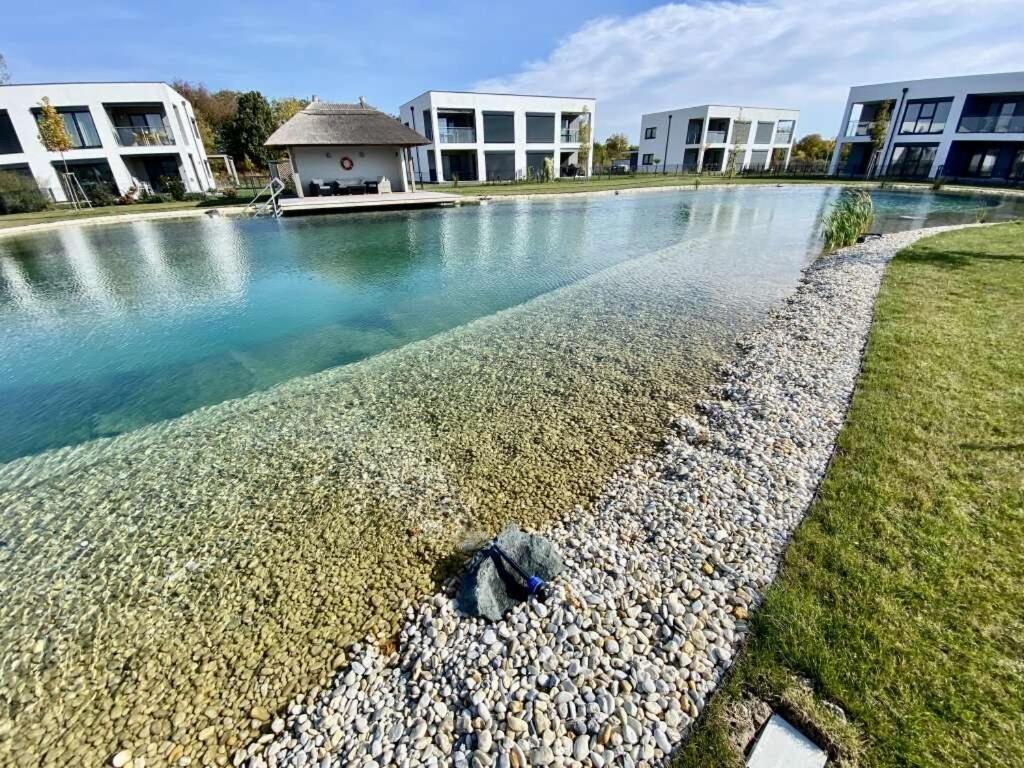 una piscina de agua frente a algunos edificios en LUXUS Appartement am Golfplatz und Therme Lutzmannsburg, en Zsira