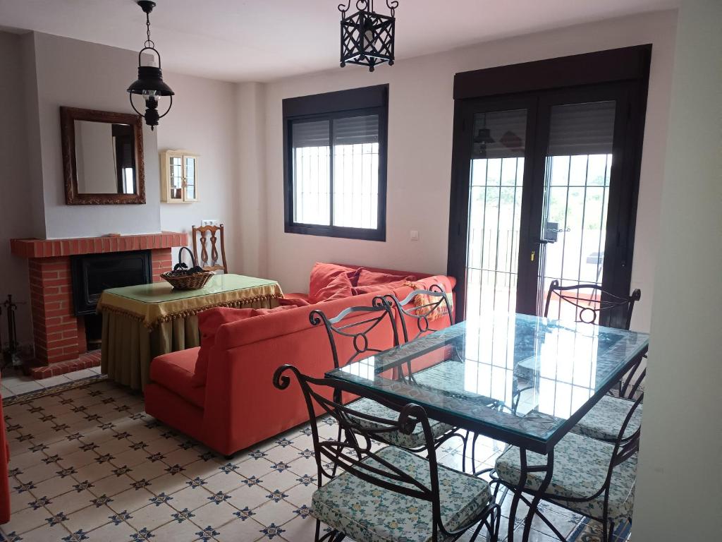 sala de estar con sofá rojo y mesa de cristal en El Corralon de Severo, en Hinojales