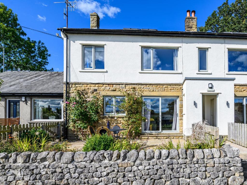 a house with a stone fence in front of it at 2 Orchard Leigh in Austwick