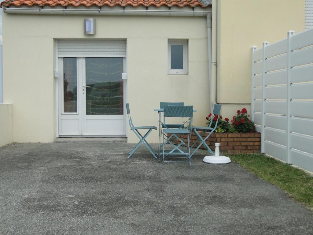 deux chaises et une table devant une maison dans l'établissement Gîte Orchidée, aux Herbiers