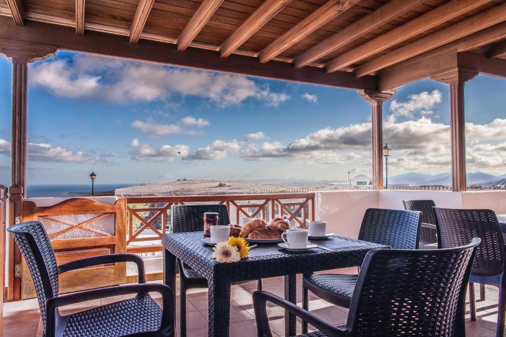 a table and chairs on a patio with a view at CASA MORRO BLANCO in Tías