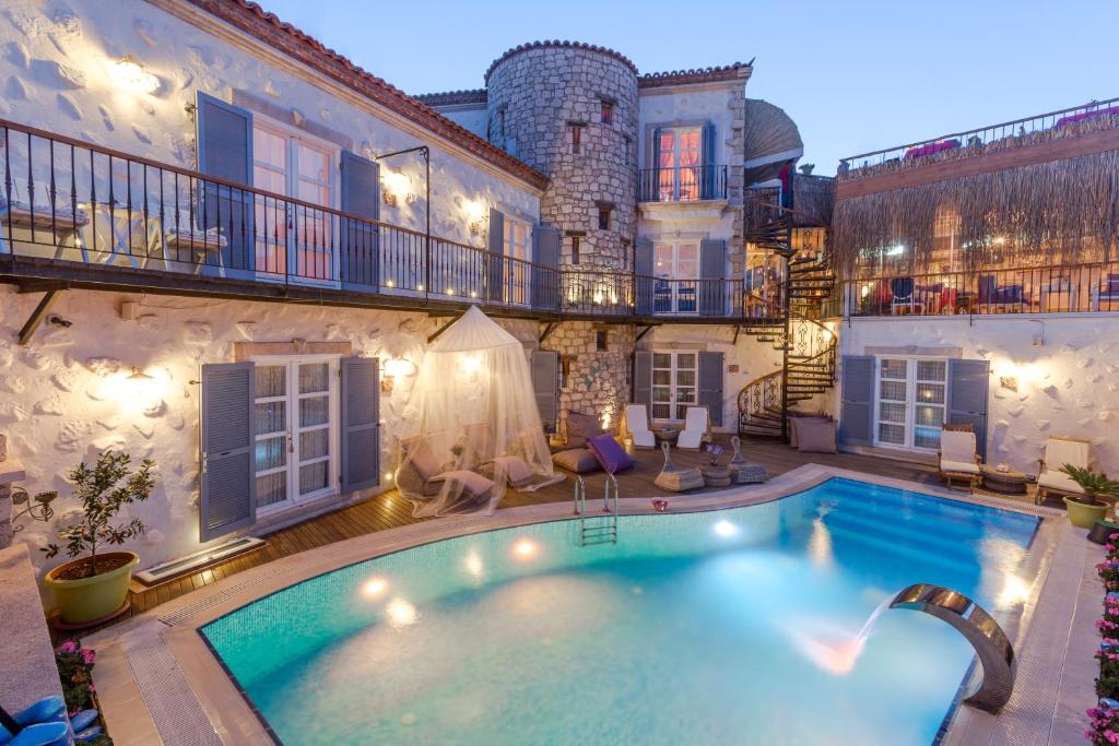 a large swimming pool in the middle of a house at Chigdem Hotel-Special Category in Alaçatı