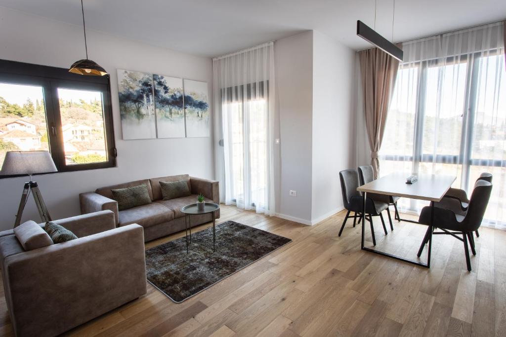 ein Wohnzimmer mit einem Sofa und einem Tisch in der Unterkunft LINA - PG, Gorica Park View Apartment in Podgorica
