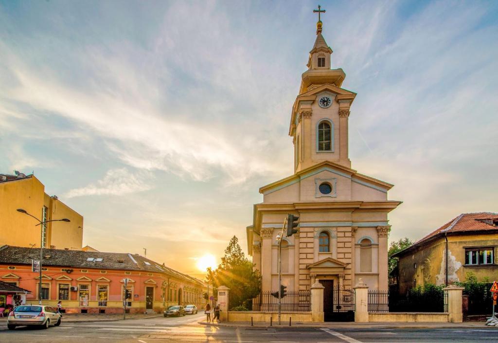 una chiesa con una torre con un orologio sopra di Hostel Stari Grad a Novi Sad