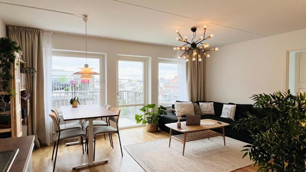 a living room with a couch and a table at Private room in Hammarby Sjöstad, common space shared! in Stockholm