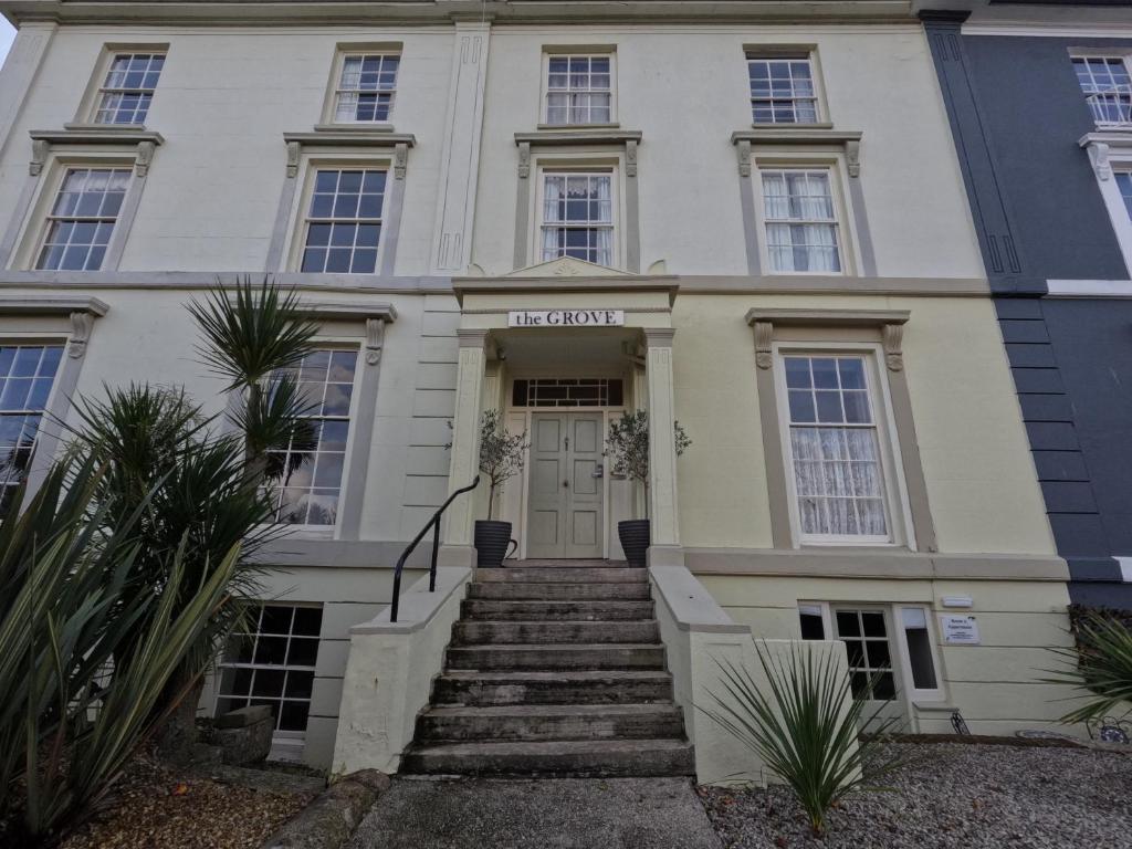 a building with a staircase leading to the front door at The Grove Falmouth in Falmouth