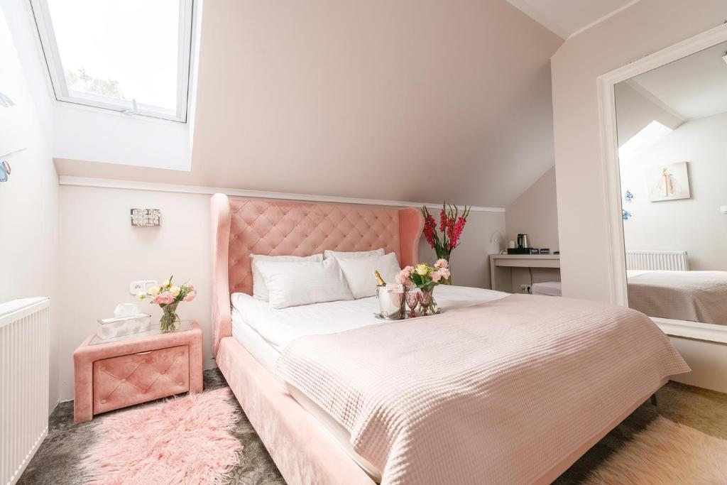 uma cama rosa com uma cabeceira rosa num quarto em PALAC DABROWKA em Rawicz