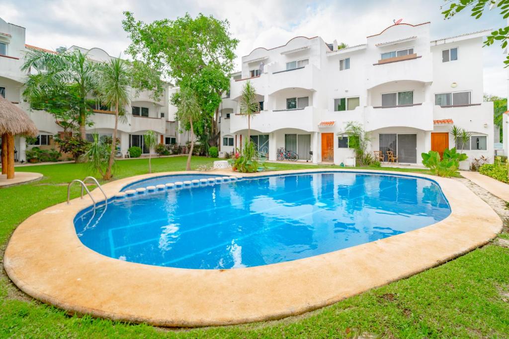 uma imagem de uma piscina em frente a um edifício em Quintas Pakal - Condo in Playacar Phase 2 - with Pool - At Quintas Pakal Complex em Playa del Carmen