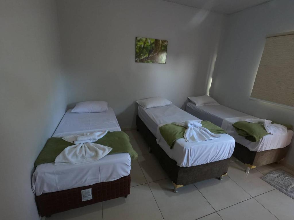 a room with three beds in a room at Rodrigo Hostel Suítes in Bonito