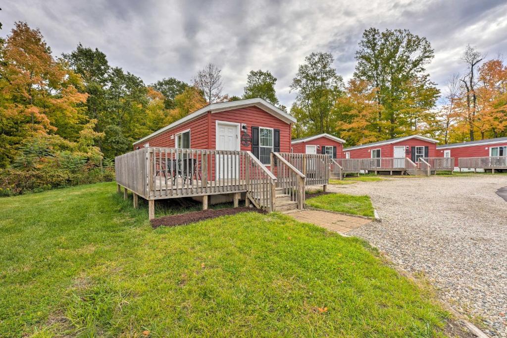 a red house with a porch and a deck at Cassopolis Cabin On-Site Boating and Fishing! in Cassopolis