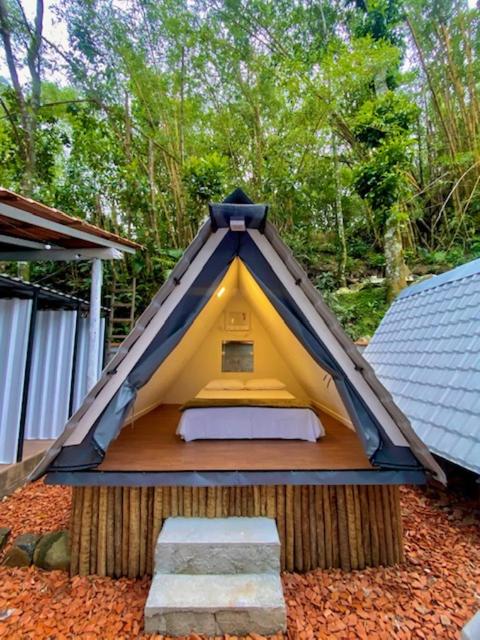 a small tent with a bed in the ground at Aquário Glamping in Abraão
