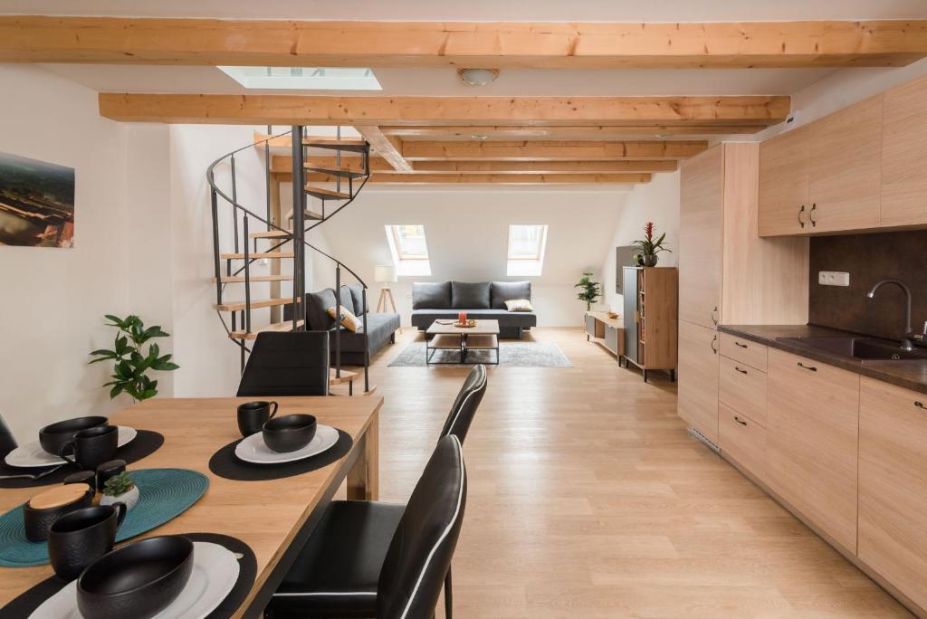 塞米利的住宿－Ayni apartman，厨房以及带木桌和椅子的客厅。
