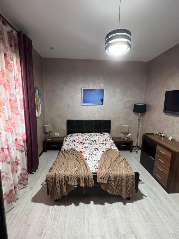 a bedroom with a bed and a desk and a tv at Casa Bia in Iaşi