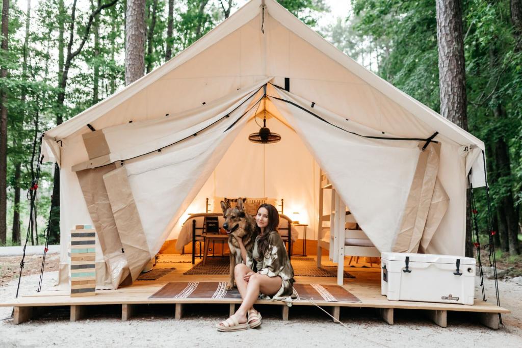 a woman and her dog in a teepee tent at Timberline Glamping at Unicoi State Park in Helen