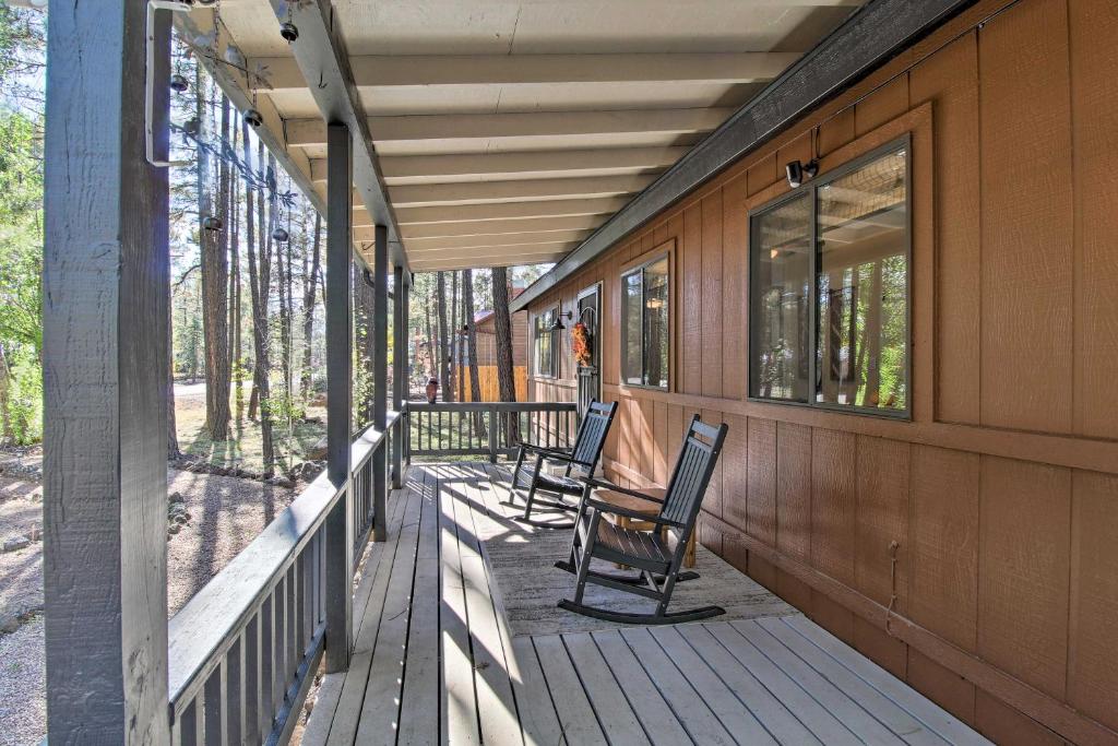 duas cadeiras sentadas no alpendre de uma casa em Bright Pinetop Cabin with Deck - Pet Friendly! em Pinetop-Lakeside