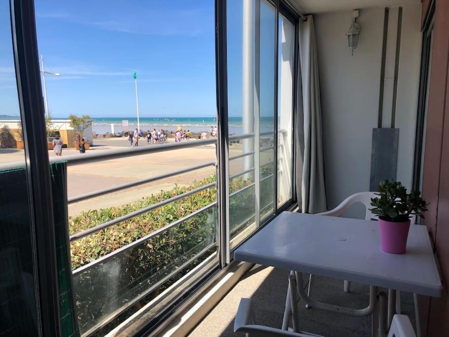 T2 Cosy Mer Plage Plérin St Brieuc في بليران: شرفة مع طاولة وإطلالة على الشاطئ