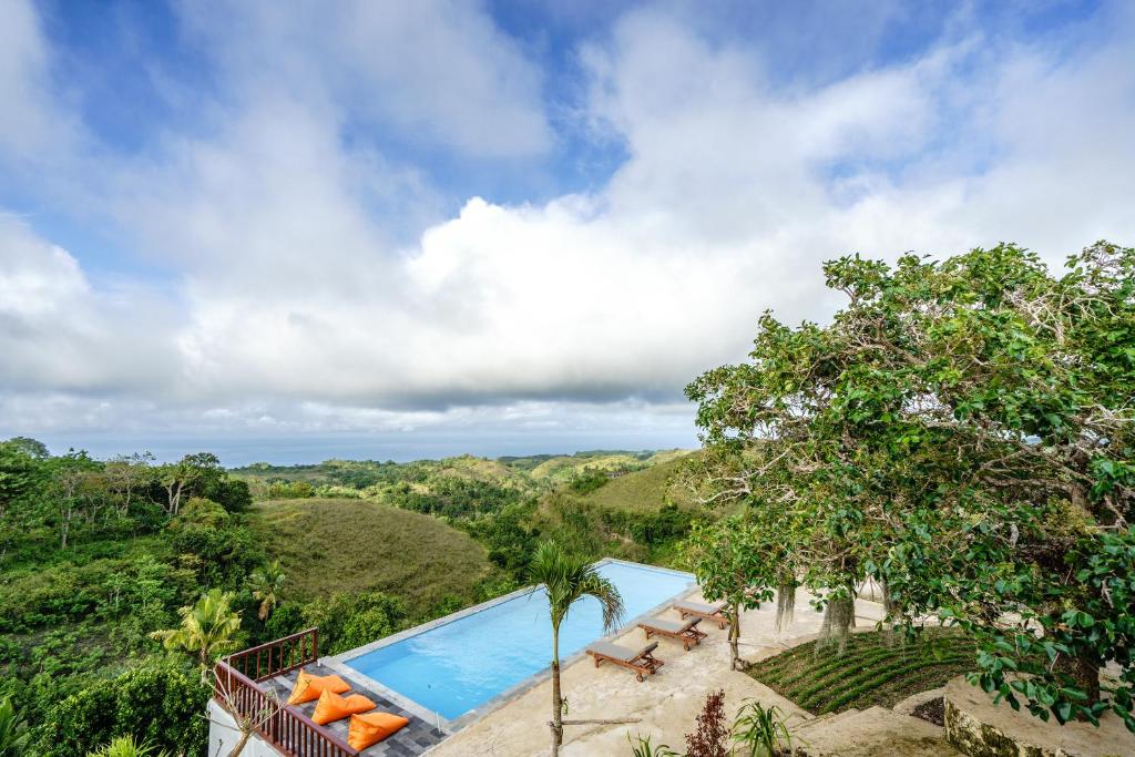 a resort with a swimming pool and trees at Pini Sentana Village Nusa Penida in Nusa Penida