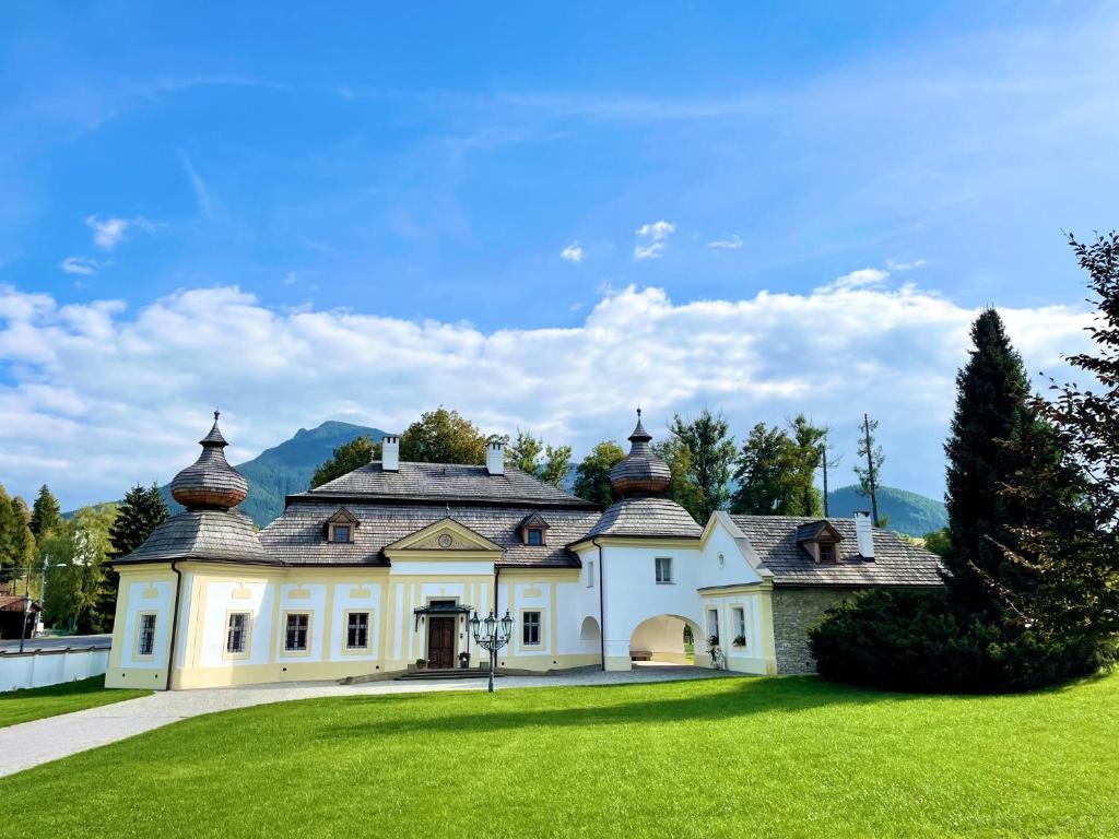 a large white house with a green lawn at Kaštieľ Kubínyi - Adult friendly in Dolný Kubín
