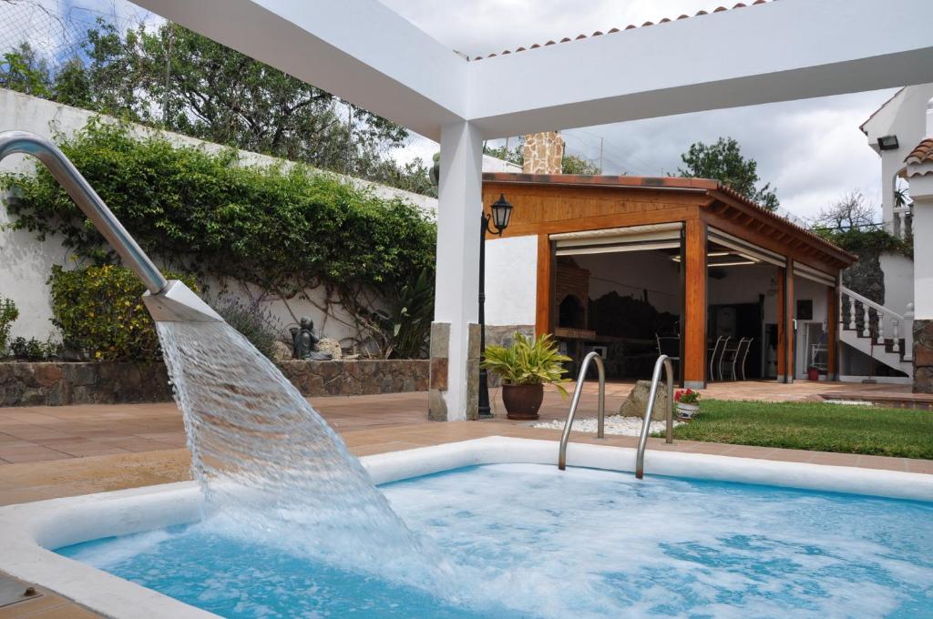 a pool with a water fountain in a yard at Bonita casa cálida para el relax con wifi in Valsequillo