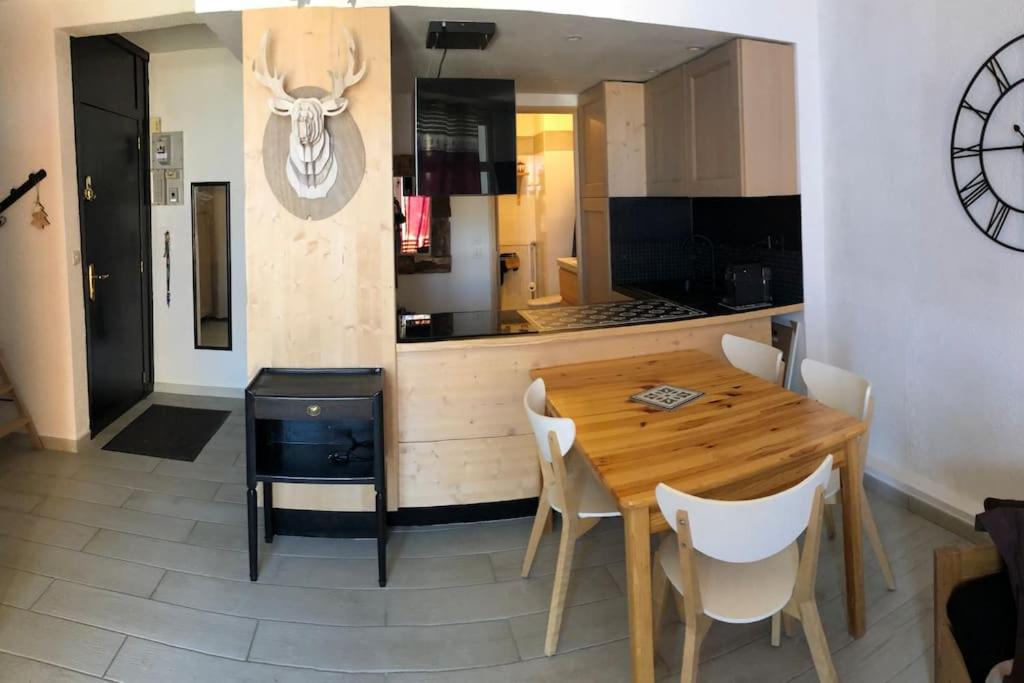 拉姆吉的住宿－Beau Studio La Mongie Tourmalet Pic du Midi，厨房配有木桌和白色椅子