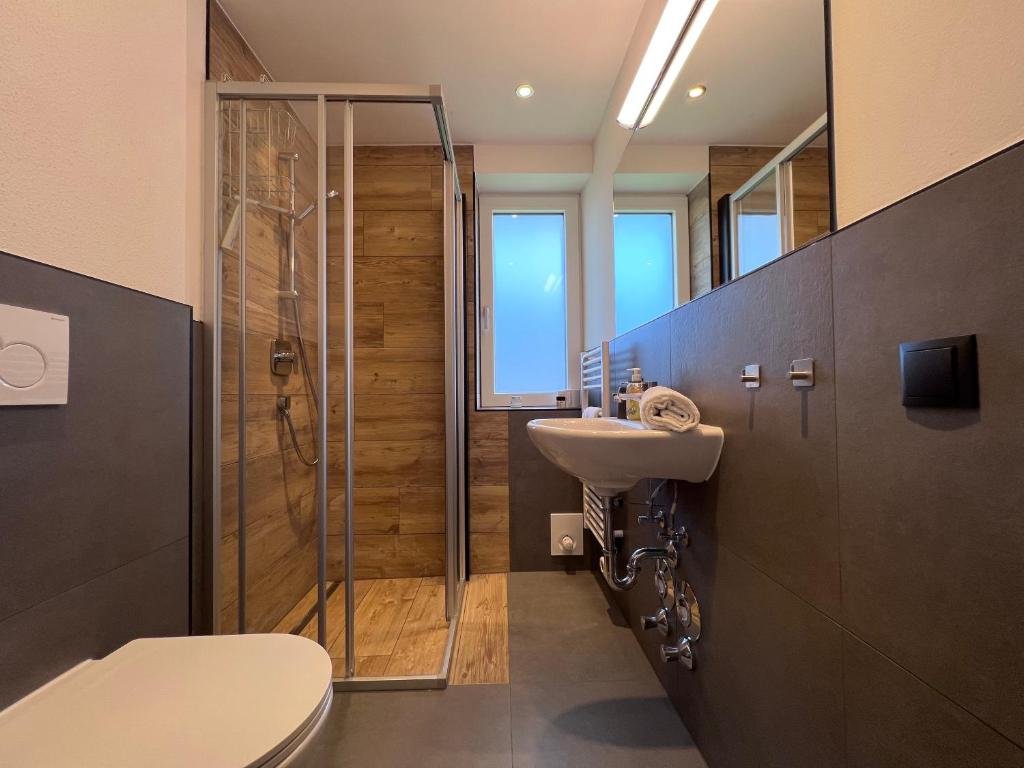 uma casa de banho com um chuveiro, um WC e um lavatório. em Apartments Monika - Altenmarkt em Altenmarkt im Pongau