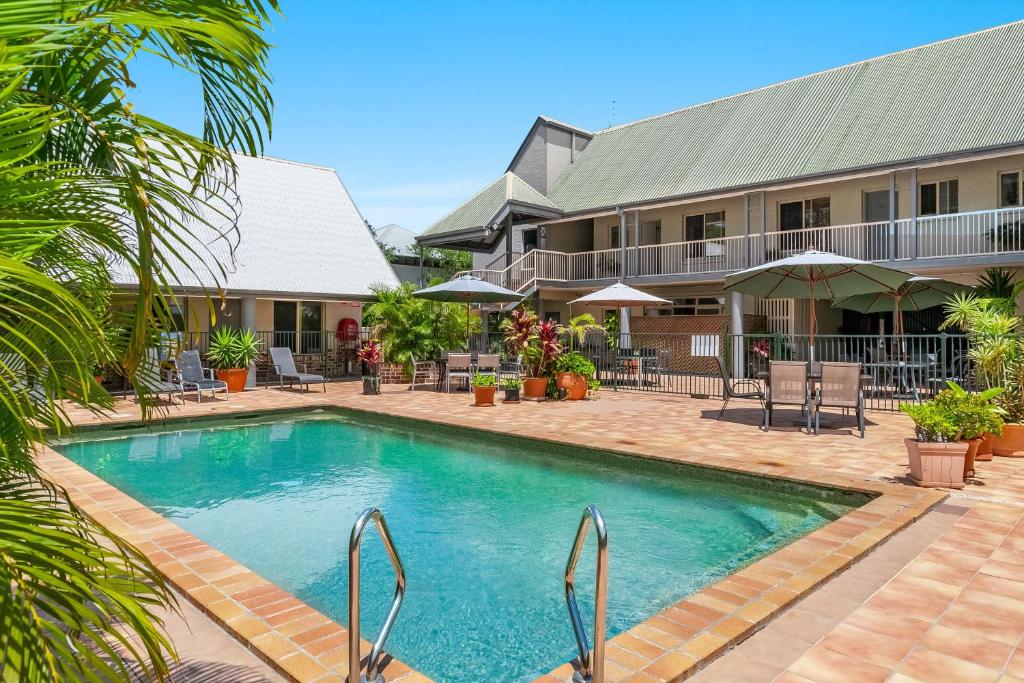 a swimming pool in front of a building at Byron Central Apartments in Byron Bay