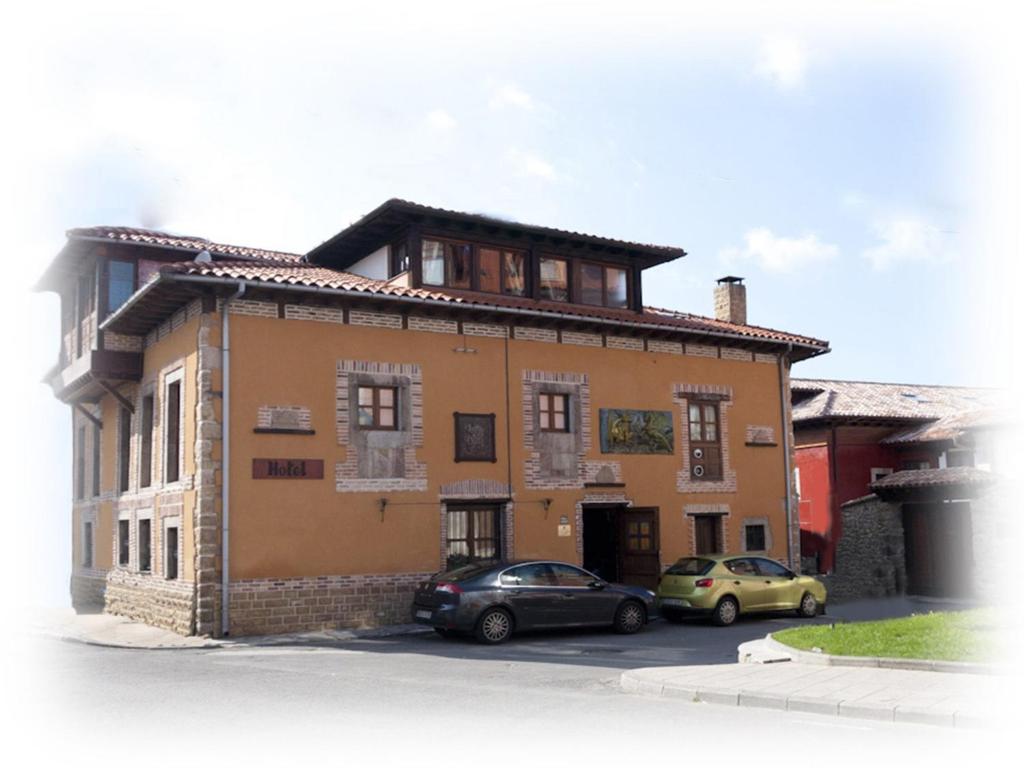 a building with two cars parked in front of it at Luna del Valle in Nueva de Llanes