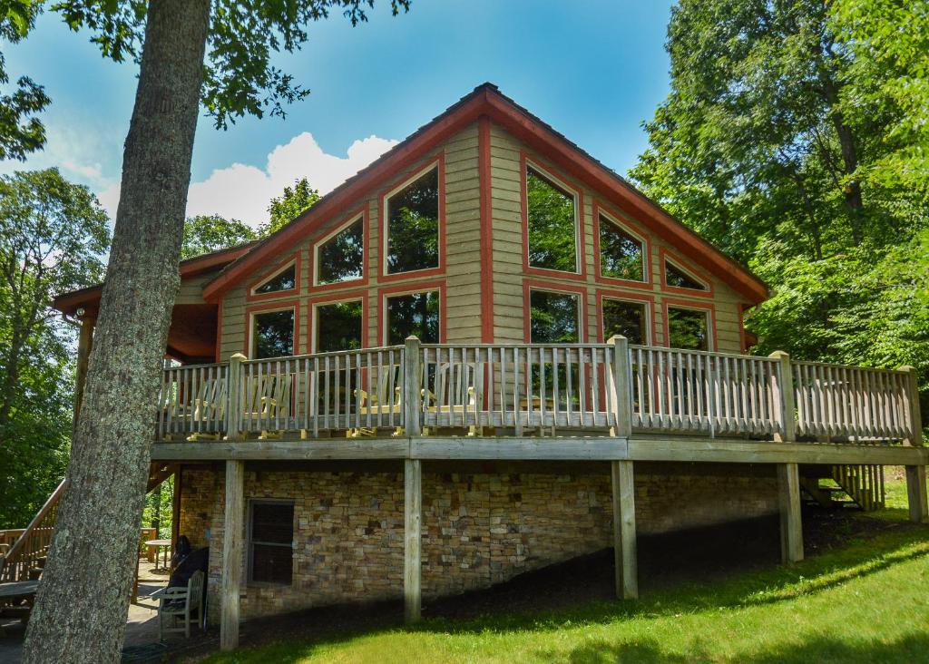 a log cabin with a large deck and a tree at One Ski Hill in McHenry