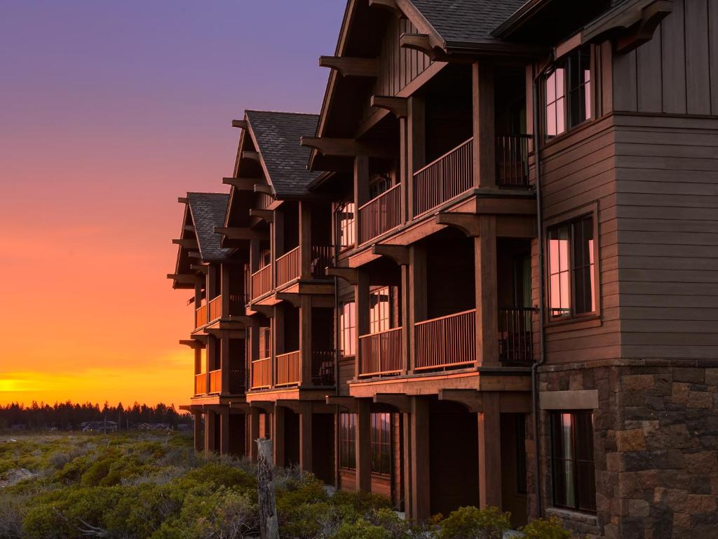 uma fila de edifícios de apartamentos com o pôr-do-sol ao fundo em Tetherow Hotel em Bend