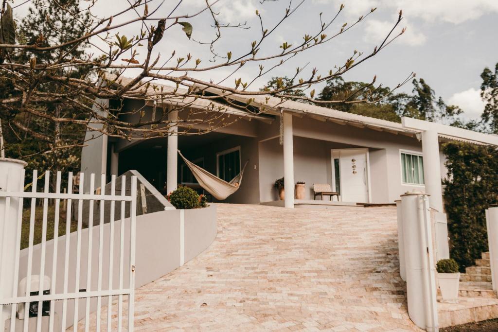 ein Haus mit einer Hängematte davor in der Unterkunft Casa confortável em local tranquilo. in Rodeio